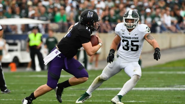 Sep 21, 2019; Evanston, IL, USA; Northwestern Wildcats quarterback Aidan Smith (11) runs against Michigan State Spartans linebacker Joe Bachie (35) during the second half at Ryan Field. Mandatory Credit: Matt Marton-USA TODAY Sports